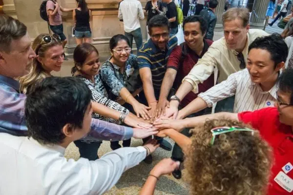 A group of diverse people joining hands in a collaborative gesture